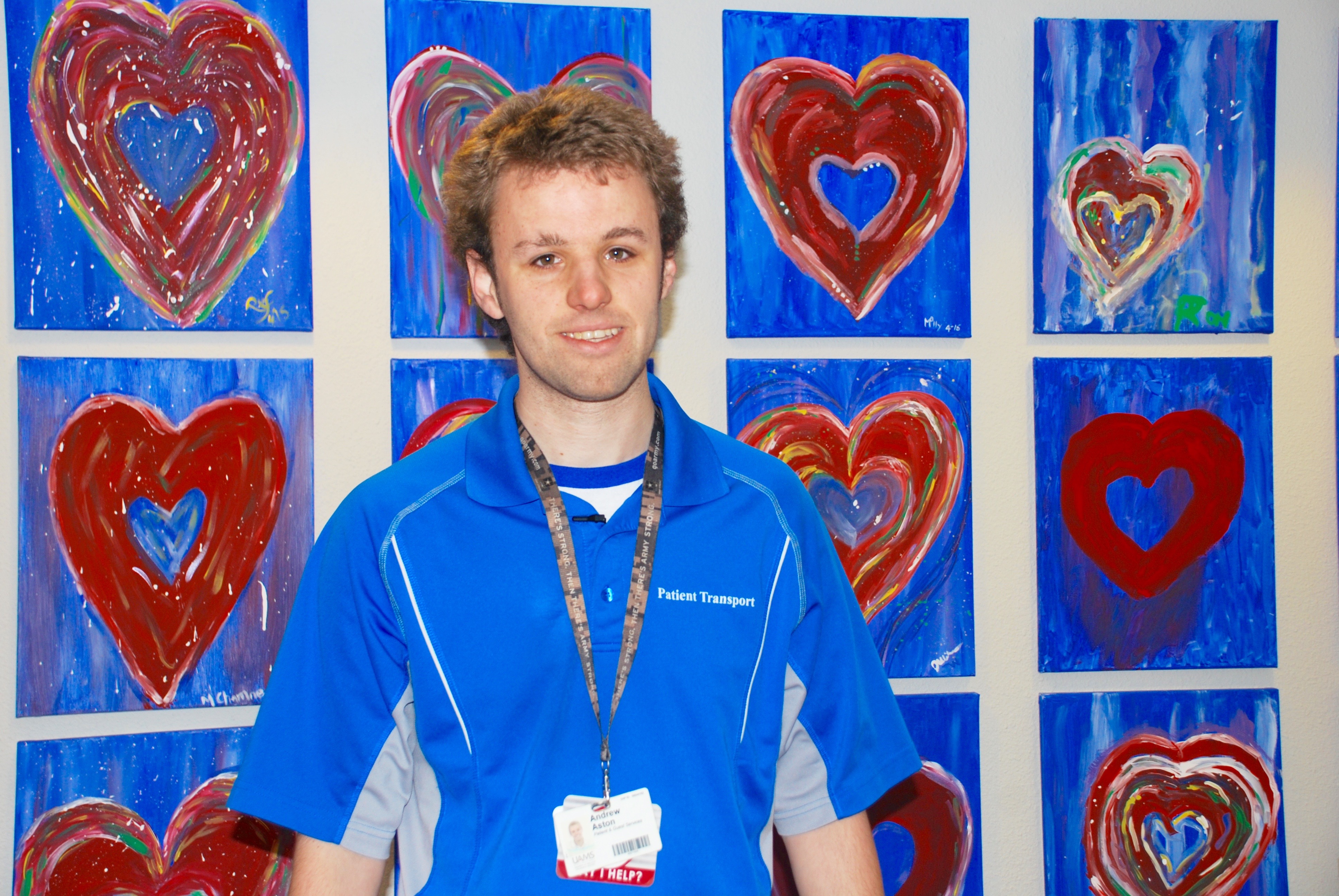 Young man standing in front of a wall filled with heart artwork